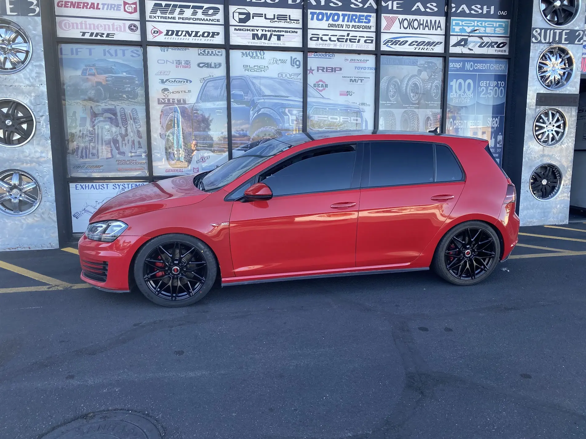 Red Volkswagen Golf GTI lowered on black wheels at SHM Motorsports
